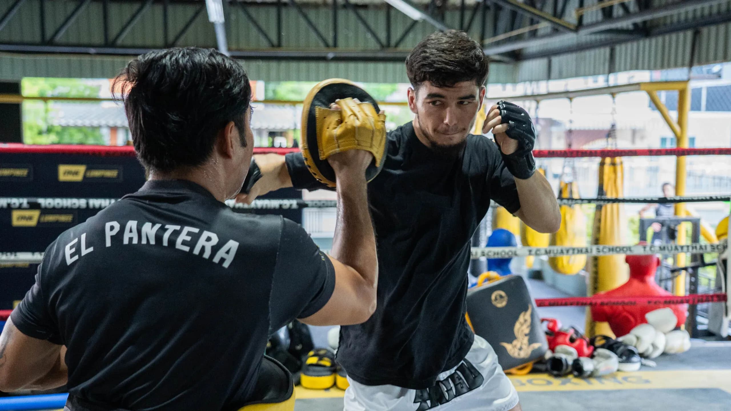 Uzbek Muay Thai fighter Aslamjon Ortikov punches focus mitts at an open workout