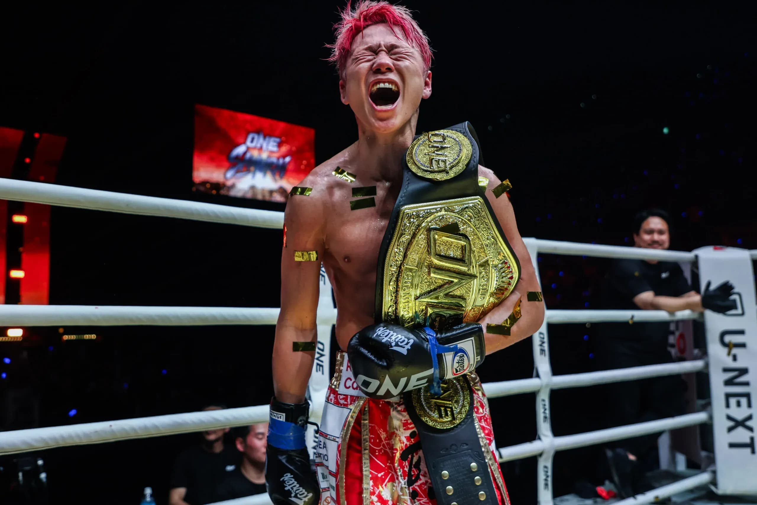 Takeru screams while posing with the ONE Championship belt in the ring