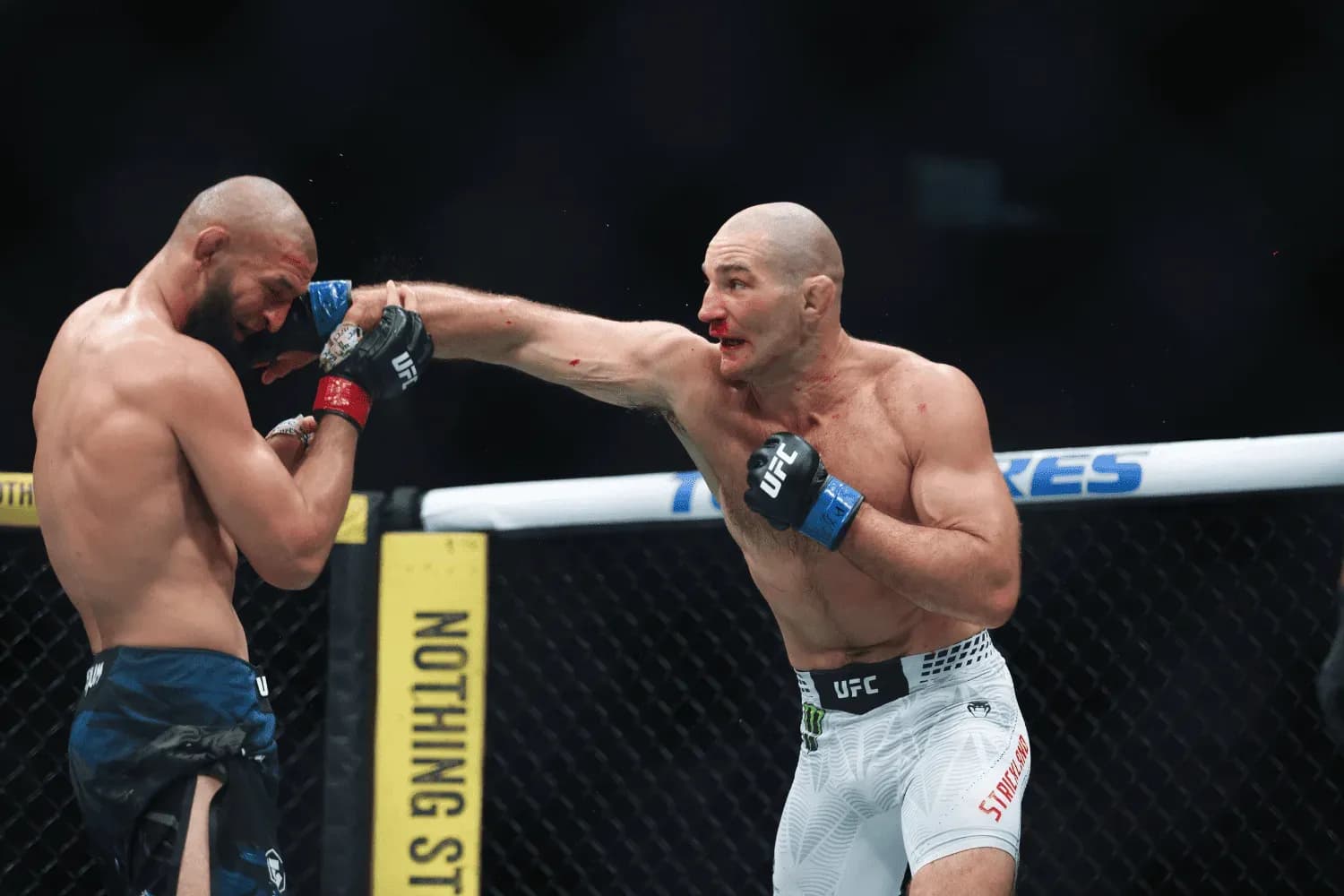 Sean Strickland punches Khamzat Chimaev during his fight against in Middleweight bout at UFC 328